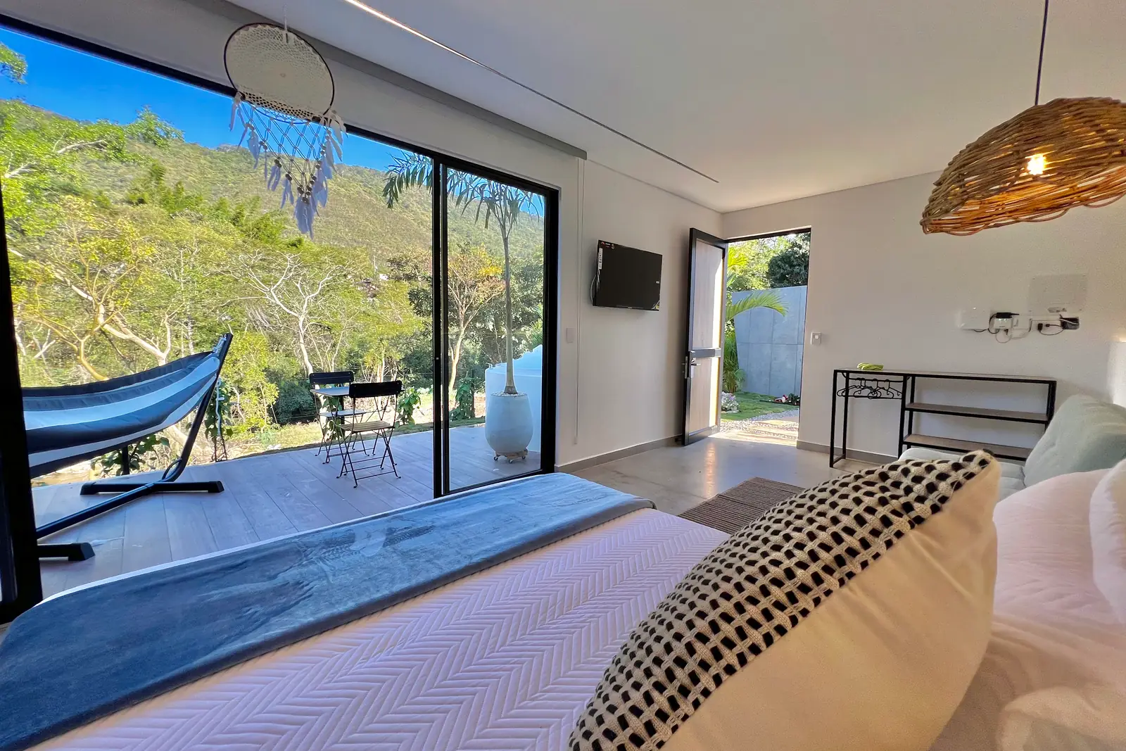 Lo que se ve desde la cama: la hamaca, la terraza y el verde de la montaña