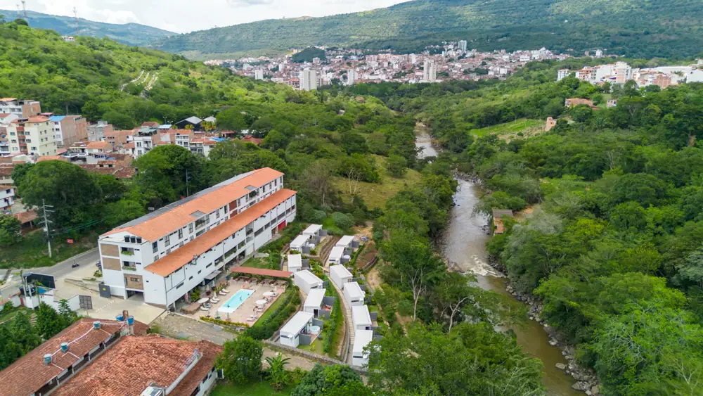 Las cabañas en la ladera, el río Fonce entre árboles y la ciudad de San Gil al fondo del valle