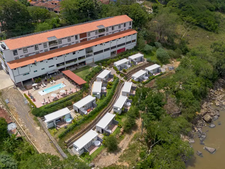 Vista aérea de las cabañas escalonadas, con el río Fonce a la derecha