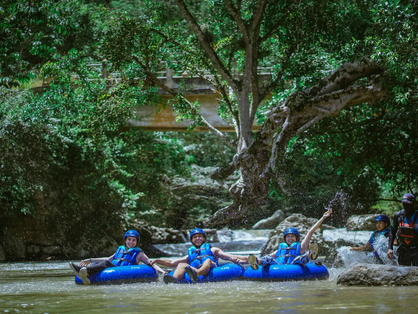 Personas bajando el río sentadas en donas inflables